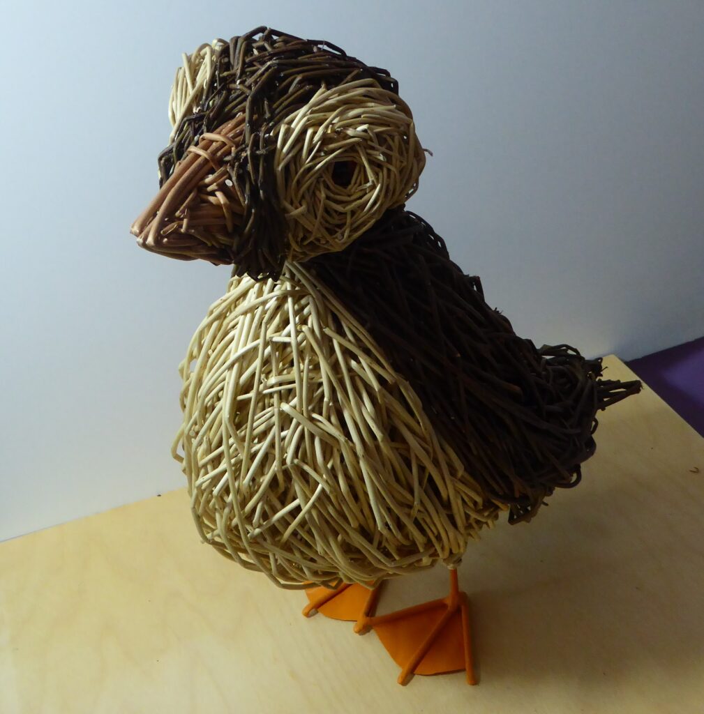 puffin bird sculpture made from willow medium an dark brown and creme belly with orange feet