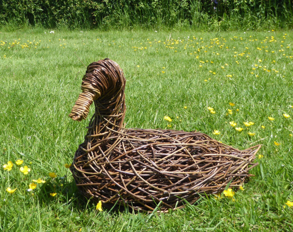 Duck willow sculpture, brown willow duck sitting on the ground