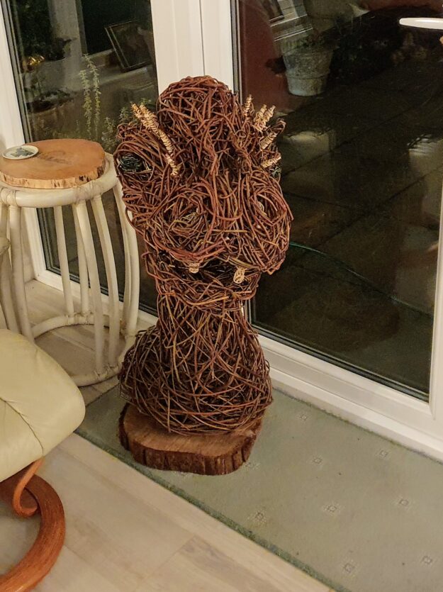 willow dragion head sculpture standing in a room in front of window 